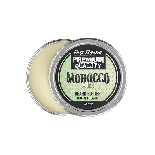 Image of a sleek 2oz metal tin of Morocco Mint scented Beard Butter with a screw-on top and tamper-evident seal, hand-poured in small batches in Canada. The tin sits against a backdrop of greenery, reflecting the natural ingredients used in the product.